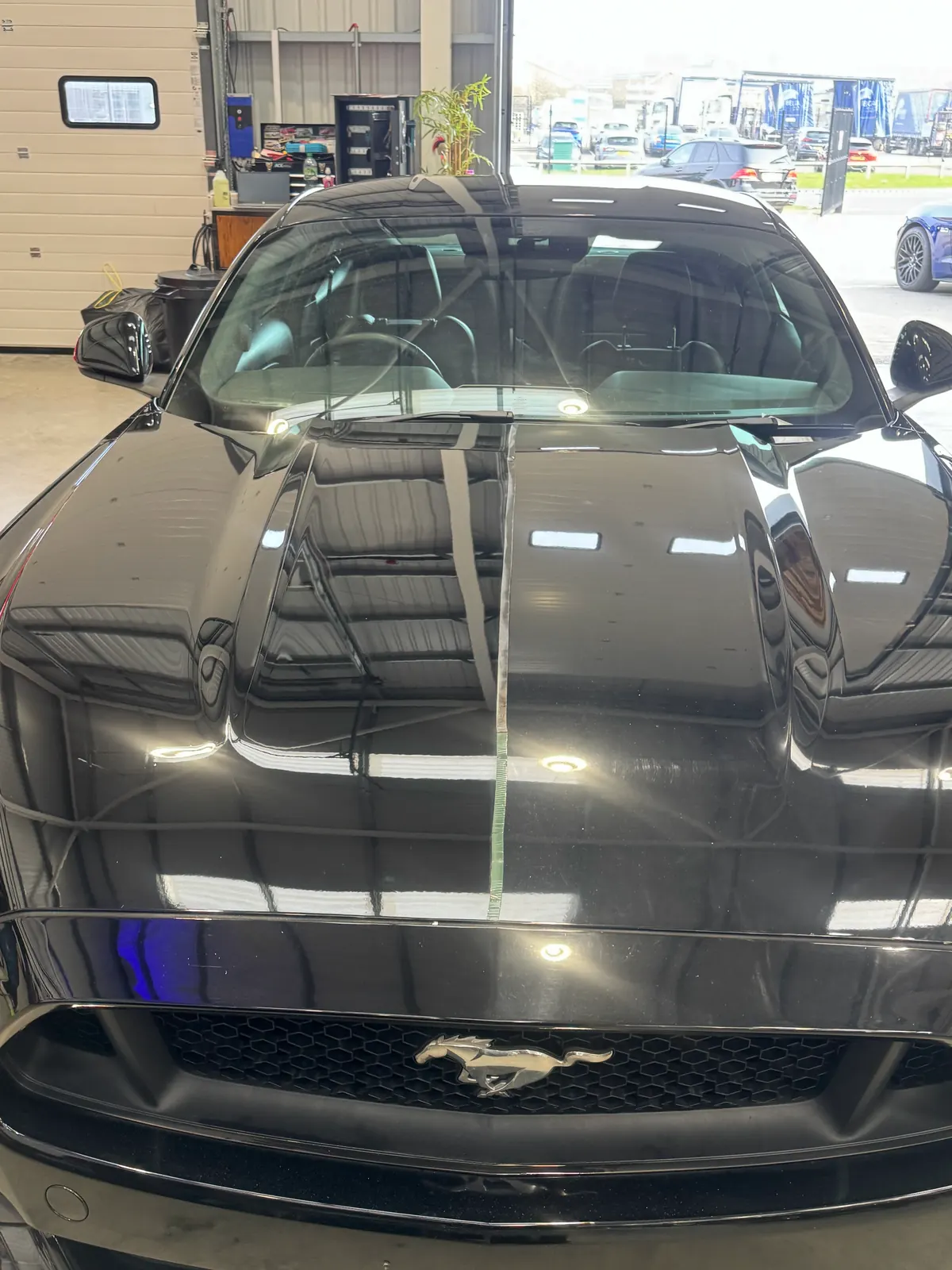 Black Ford Mustang with a mirror-like gloss finish inside the OCD unit in Halifax